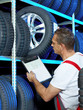 Car mechanic looking for a tire with registration certificate