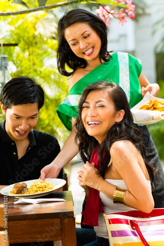Photo: Asian man and woman in tropical restaurant Asian man and woman in tropical restaurant