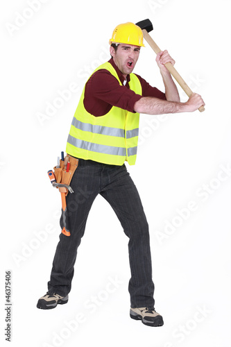 Photo: Construction worker smashing with a sledgehammer Construction worker smashing with a sledgehammer