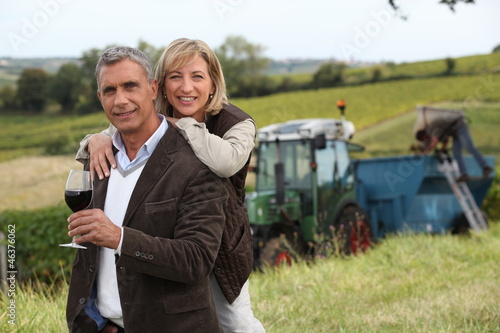 Photo: Couple with wine glass in front of vineyard Couple with wine glass in front of vineyard