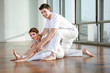 Male Yoga Instructor Assisting Woman