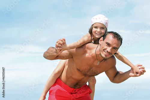 Photo: Girl on the back of father Girl on the back of father