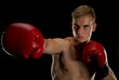 Isolated on a black background boxer extends his right jab
