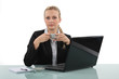 A businesswoman having a cup of coffee in her office.