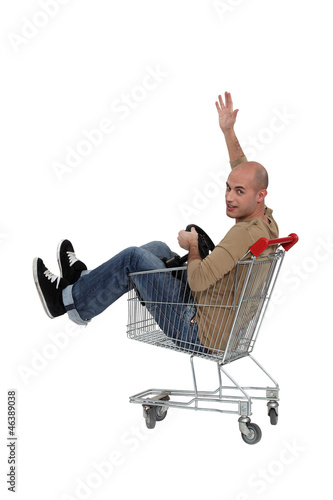Photo: Bald man sat in trolley with steering wheel Bald man sat in trolley with steering wheel