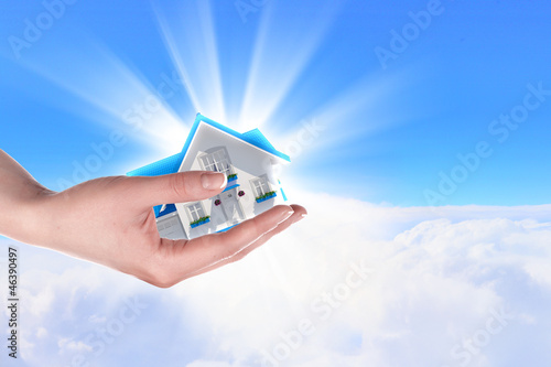 Photo: the house in hands on blue sky the house in hands on blue sky