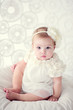 cute baby girl in white fashion dress with flower on her hair