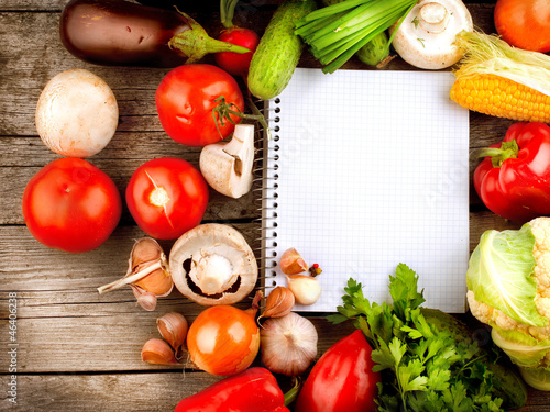 Photo: Open Notebook and Fresh Vegetables Background. Diet Open Notebook and Fresh Vegetables Background. Diet