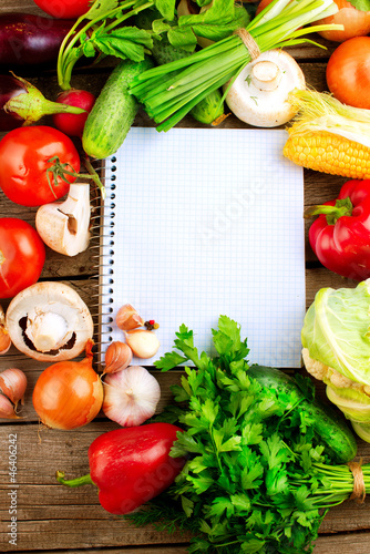 Photo: Open Notebook and Fresh Vegetables Background. Diet Open Notebook and Fresh Vegetables Background. Diet