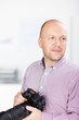 lächelnder fotograf im büro
