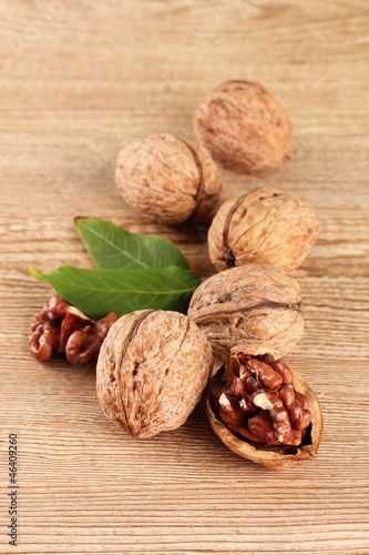 Photo: walnuts with green leaves, on wooden background walnuts with green leaves, on wooden background
