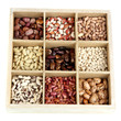 Diverse beans in wooden box sections isolated on white