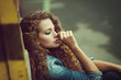 Foto: Beautiful young Caucasian girl with curly hair outdoors Beautiful young Caucasian girl with curly hair outdoors