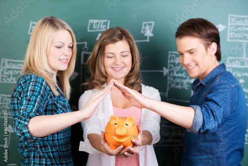 Photo: drei studenten mit sparschwein drei studenten mit sparschwein