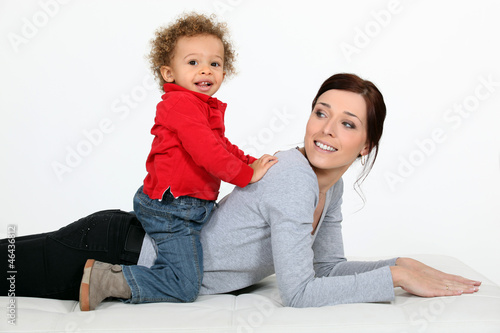 Photo: Little boy on his mother back. Little boy on his mother back.