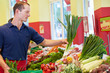 Supermarkt-Azubi füllt Gemüsestand auf