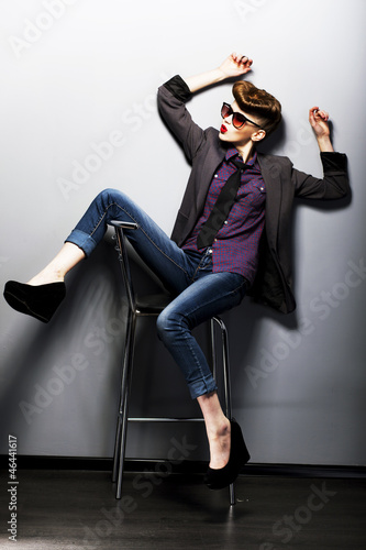 Photo: Pin-up girl in sunglasses sitting. American retro style Pin-up girl in sunglasses sitting. American retro style