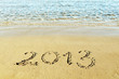 The inscription "2013" on a beach sand