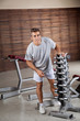 Man Standing By Dumbbells In Rack