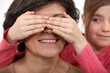Granddaughter covering grandmas eyes