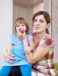 woman wipes snot  child at home