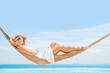Foto: view of nice young lady swinging in hummock on tropical beach view of nice young lady swinging in hummock on tropical beach