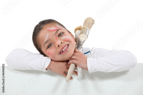 Photo: Messy little girl holding paint equipment Messy little girl holding paint equipment