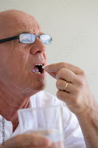 Photo: Elderly man swallowing a pill Elderly man swallowing a pill
