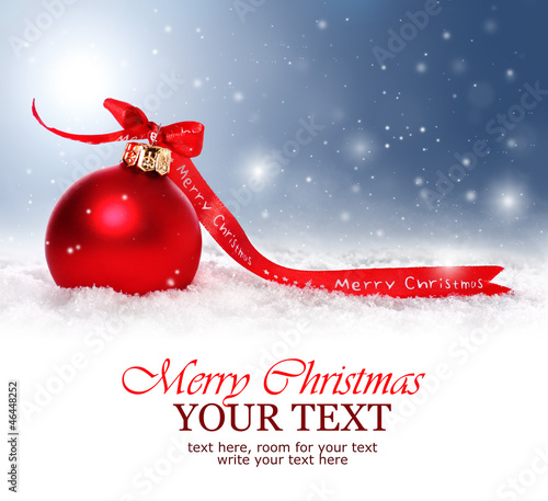 Photo: Christmas background with red bauble with snow and snowflakes Christmas background with red bauble with snow and snowflakes