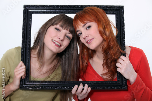 Photo: Women holding wooden frame Women holding wooden frame