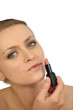 woman putting lipstick