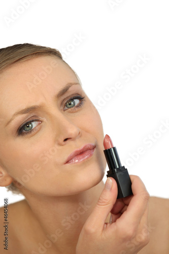 Photo: woman putting lipstick woman putting lipstick