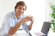 Photo: Young and handsome man drinking his coffee during a work break Young and handsome man drinking his coffee during a work break