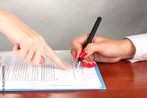 Photo: signing of treaty on wooden table on color background signing of treaty on wooden table on color background