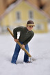 Foto: Mann beim Schneeschaufeln vor einem Haus Mann beim Schneeschaufeln vor einem Haus