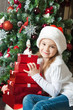 Happy little girl in Santa hat with gifts