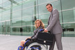 woman in a wheelchair and man helping