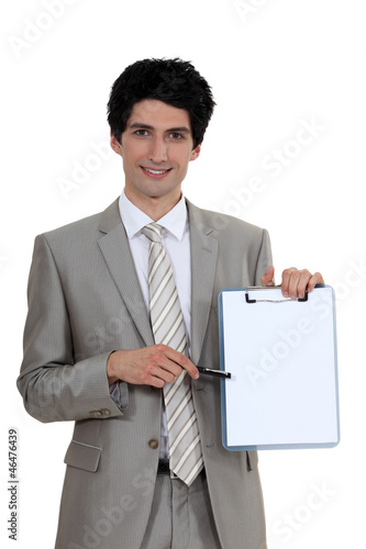Photo: Businessman pointing to a blank clipboard Businessman pointing to a blank clipboard