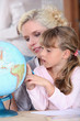 Mum and daughter looking at a globe