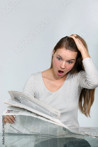 Photo: Shocked woman reading a newspaper Shocked woman reading a newspaper