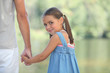 Photo: Young girl walking by the lake with her parents Young girl walking by the lake with her parents