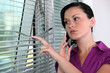 Woman peeking though window blinds