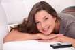 A cute brunette resting on her sofa.