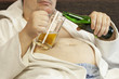 Foto: Man sitting on the couch with a beer in the hands of Man sitting on the couch with a beer in the hands of