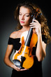 Woman with violin in dark room