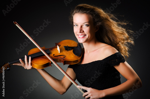 Photo: Woman with violin in dark room Woman with violin in dark room