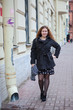 Pretty woman in the city streets standing near waterdrain