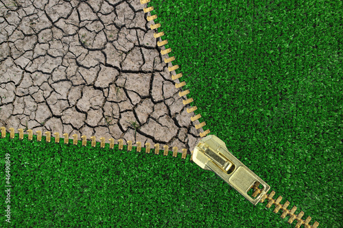 Photo: Global Warming. Zipper with cracked earth and grass Global Warming. Zipper with cracked earth and grass