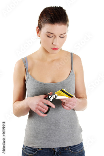 Photo: Sad young woman has to destroy her credit card Sad young woman has to destroy her credit card