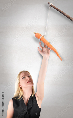 Photo: Woman Reaching for Carrot Stick Woman Reaching for Carrot Stick